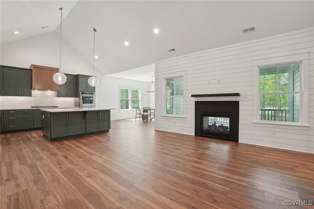 9088 Terroir Ln, New Kent, VA 23124 - kitchen featuring oven, light countertops, high vaulted ceiling, open floor plan, and visible vents