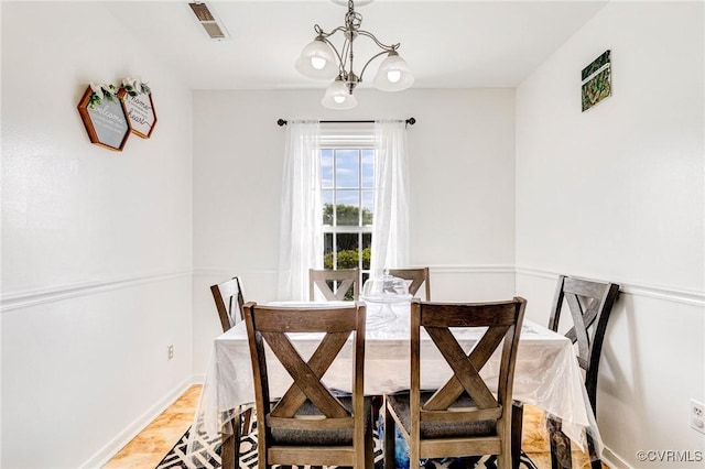 dining room featuring baseboards, visible vents, and a chandelier