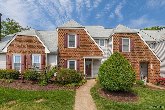 view of front of house featuring brick siding and a front lawn