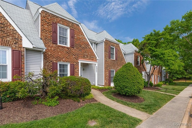 view of front of property featuring brick siding and a front yard