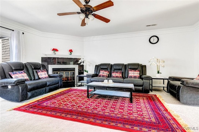 carpeted living room with visible vents, crown molding, a fireplace with flush hearth, and ceiling fan