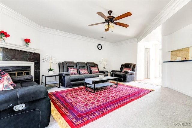 living room with crown molding, a ceiling fan, carpet floors, and a fireplace