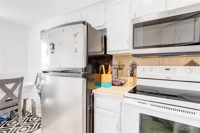 kitchen featuring light countertops, appliances with stainless steel finishes, backsplash, and white cabinetry
