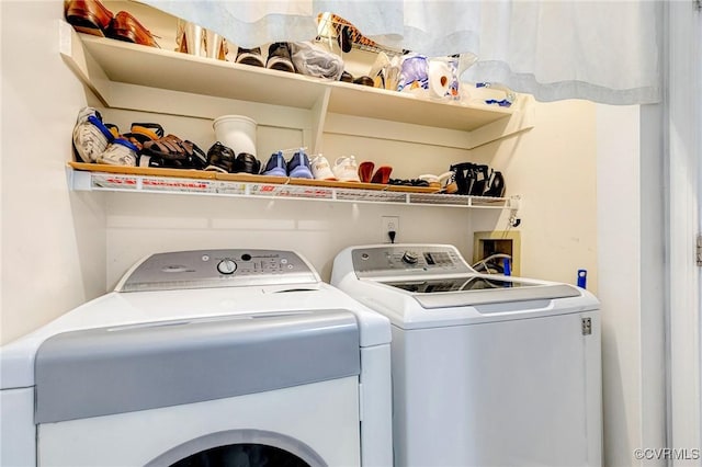clothes washing area featuring separate washer and dryer and laundry area