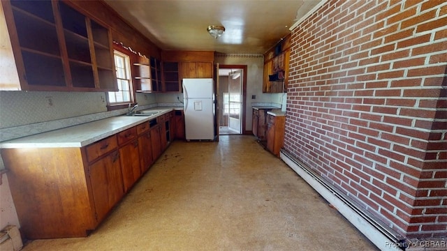 kitchen with open shelves, baseboard heating, light countertops, a sink, and freestanding refrigerator