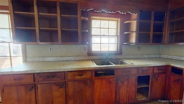 kitchen with a sink, open shelves, and backsplash