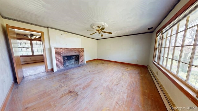 unfurnished living room featuring baseboards, ceiling fan, a fireplace, and wood finished floors
