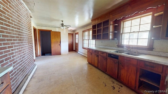 kitchen featuring a sink, open shelves, baseboard heating, and a healthy amount of sunlight