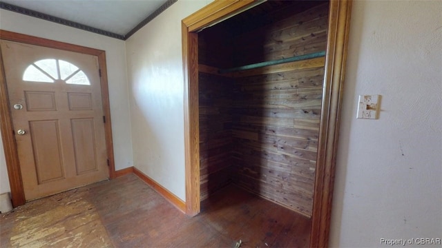 foyer with baseboards, ornamental molding, and wood finished floors