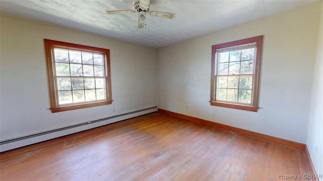 unfurnished room with baseboards, a ceiling fan, wood finished floors, and baseboard heating