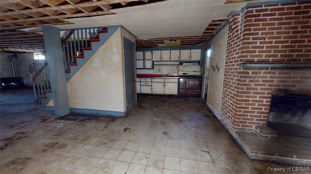 basement with baseboards, a sink, and stairway