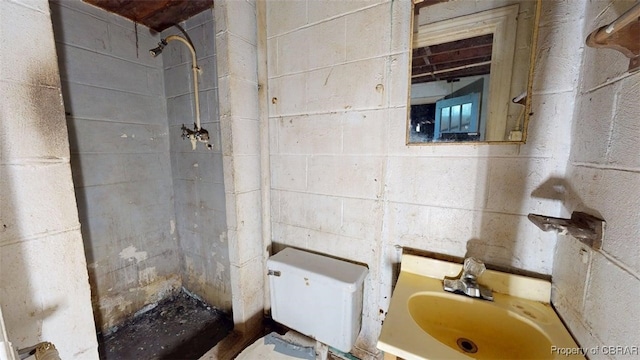 full bathroom with toilet, tiled shower, and vanity