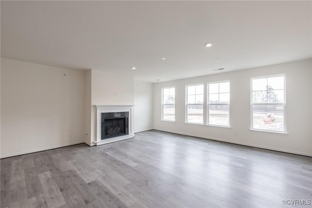 4118 Ebbies Xing, Midlothian, VA 23112 - unfurnished living room featuring baseboards, wood finished floors, a wealth of natural light, and a fireplace