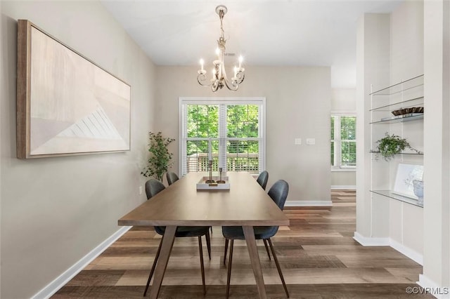 dining area with wood finished floors, a chandelier, baseboards, and plenty of natural light