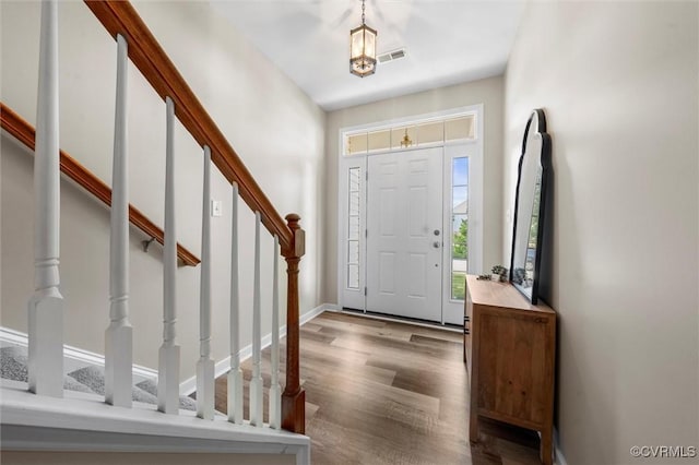 entryway featuring stairs, wood finished floors, and baseboards