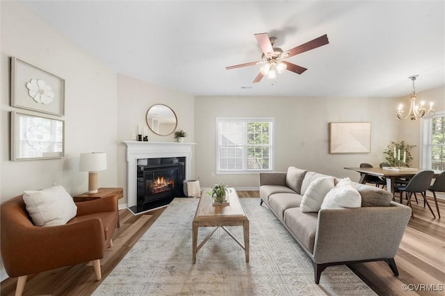living room featuring healthy amount of natural light, a chandelier, and light wood-style floors