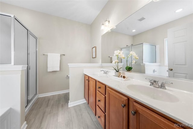 full bathroom featuring a shower stall, baseboards, and double vanity
