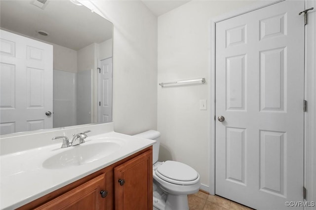 bathroom with tile patterned flooring, toilet, and vanity