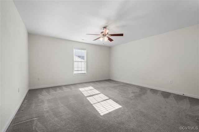 carpeted spare room with a ceiling fan and baseboards