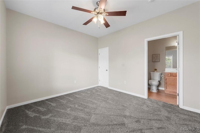 unfurnished bedroom featuring carpet, baseboards, ensuite bathroom, and a ceiling fan