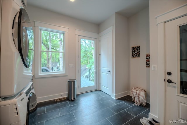 4629 Butte Rd, Richmond, VA 23235 - doorway to outside featuring stacked washing machine and dryer, baseboards, and dark tile patterned flooring