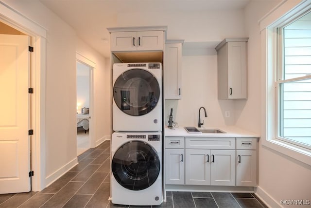 4629 Butte Rd, Richmond, VA 23235 - laundry area featuring stacked washer / dryer, cabinet space, plenty of natural light, and baseboards