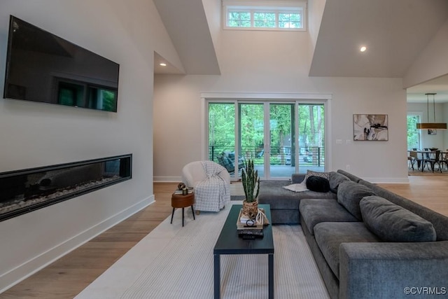 4629 Butte Rd, Richmond, VA 23235 - living room featuring high vaulted ceiling, baseboards, wood finished floors, a glass covered fireplace, and recessed lighting