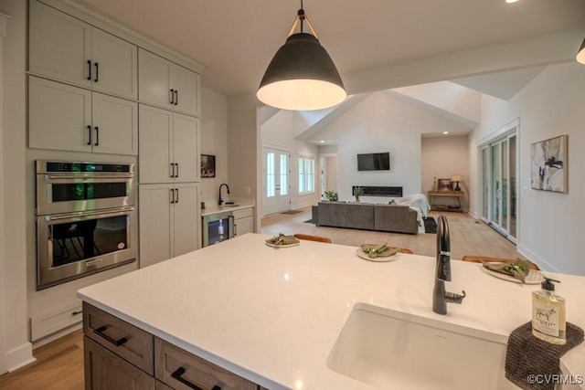 4629 Butte Rd, Richmond, VA 23235 - kitchen featuring wine cooler, double oven, a sink, light countertops, and hanging light fixtures