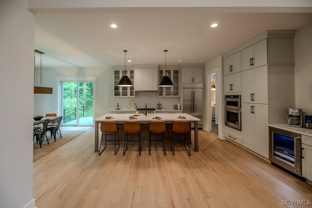 4629 Butte Rd, Richmond, VA 23235 - kitchen featuring appliances with stainless steel finishes, light wood finished floors, a kitchen bar, wine cooler, and recessed lighting