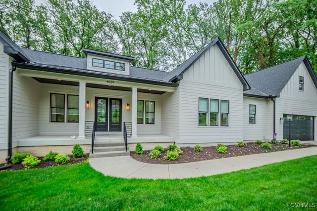 4629 Butte Rd, Richmond, VA 23235 - view of front of property with board and batten siding, a porch, a front lawn, and a shingled roof