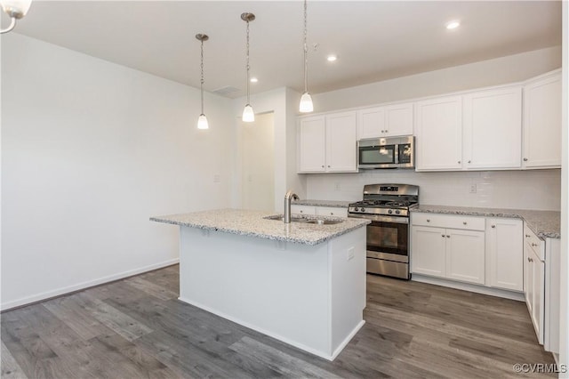 kitchen with white cabinetry, a sink, dark wood finished floors, appliances with stainless steel finishes, and backsplash