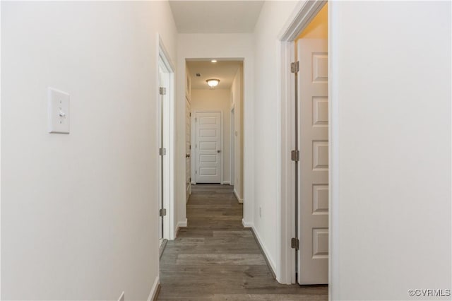 hall featuring baseboards and wood finished floors