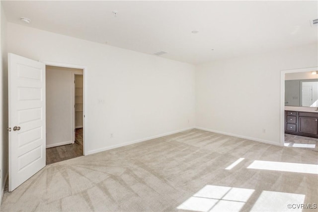 carpeted empty room featuring baseboards and visible vents