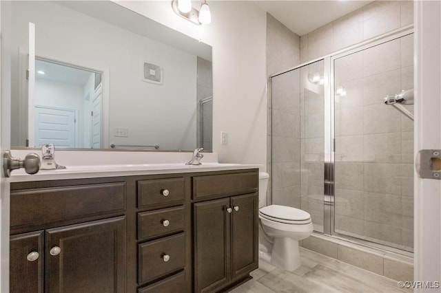 full bath with double vanity, a shower stall, toilet, and a sink