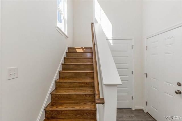 stairway featuring baseboards and wood finished floors