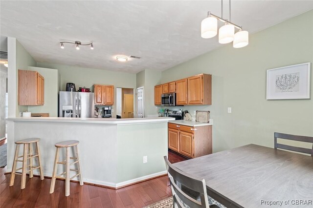 921 Hanson Dr, Newport News, VA 23602 - kitchen featuring a peninsula, a breakfast bar area, dark wood-type flooring, light countertops, and stainless steel appliances
