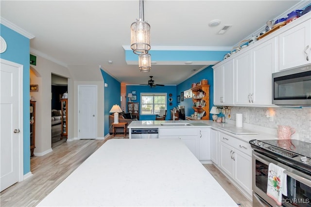 4716 Fulton St, Richmond, VA 23231 - kitchen with stainless steel appliances, a sink, crown molding, white cabinets, and tasteful backsplash