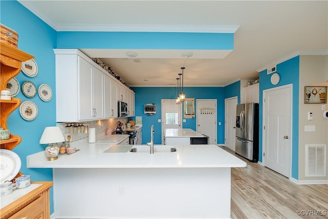 4716 Fulton St, Richmond, VA 23231 - kitchen with appliances with stainless steel finishes, a sink, a peninsula, light countertops, and white cabinetry