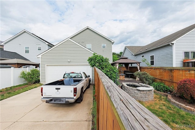 4716 Fulton St, Richmond, VA 23231 - view of side of property with a gazebo, concrete driveway, fence, and an attached garage
