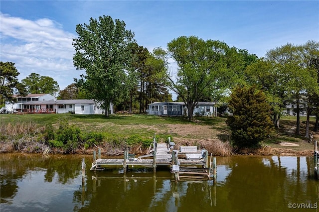 dock area featuring boat lift, a water view, and a yard