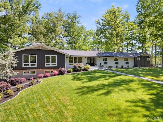 single story home featuring board and batten siding, a chimney, and a front yard
