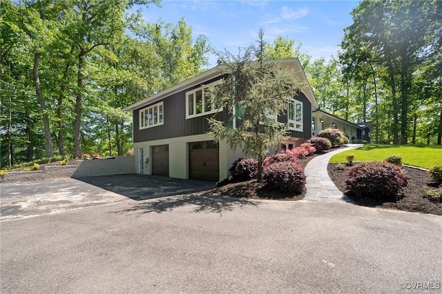 view of side of home featuring driveway and a garage