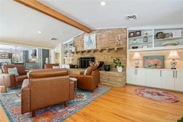 living room with visible vents, vaulted ceiling with beams, and light wood finished floors