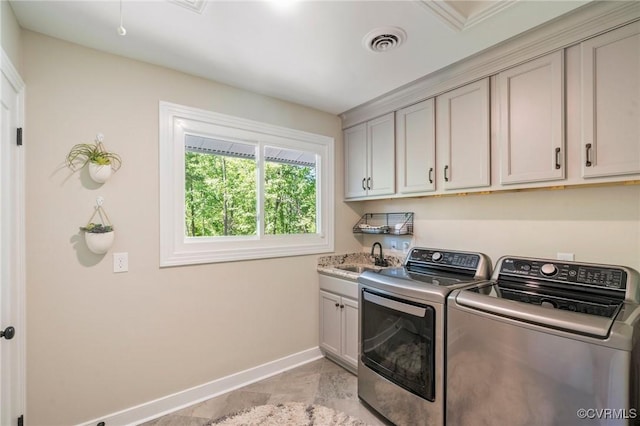 laundry area with visible vents, cabinet space, a sink, baseboards, and washer and clothes dryer
