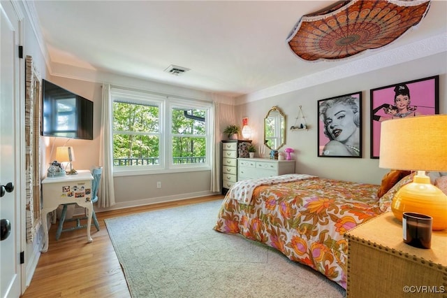 bedroom featuring baseboards, visible vents, and light wood-style floors