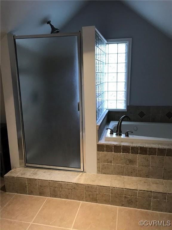 full bathroom featuring a bath, lofted ceiling, tile patterned flooring, and a stall shower