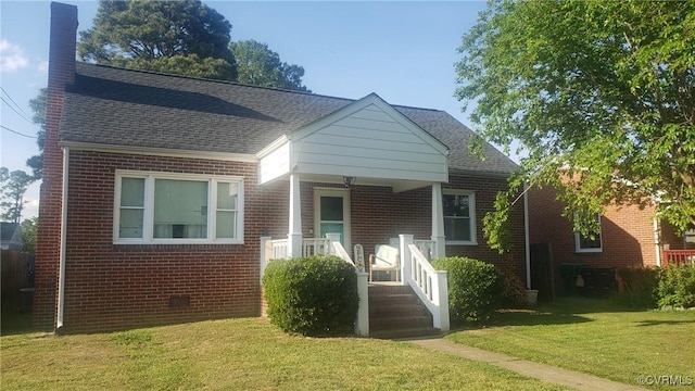 bungalow-style house featuring roof with shingles, a front lawn, and brick siding