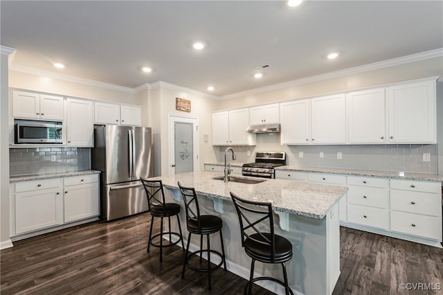 7585 Sedge Dr, New Kent, VA 23124 - kitchen featuring stainless steel appliances, under cabinet range hood, backsplash, dark wood-style floors, and a kitchen island with sink