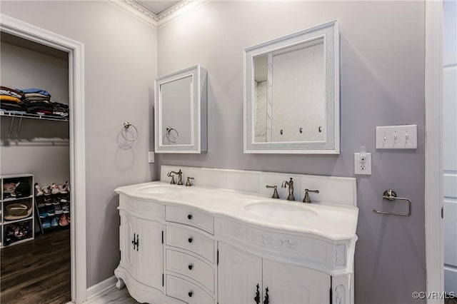 7585 Sedge Dr, New Kent, VA 23124 - bathroom featuring double vanity, crown molding, a spacious closet, and wood finished floors