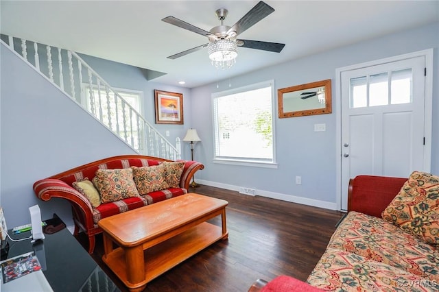 living room with a healthy amount of sunlight, baseboards, ceiling fan, and stairs